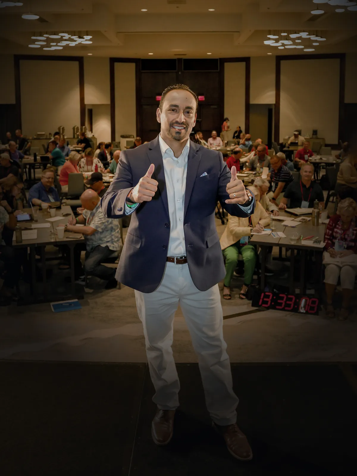 Juan P. Ortega giving a thumbs-up in front of a packed conference audience in Honolulu, 2022